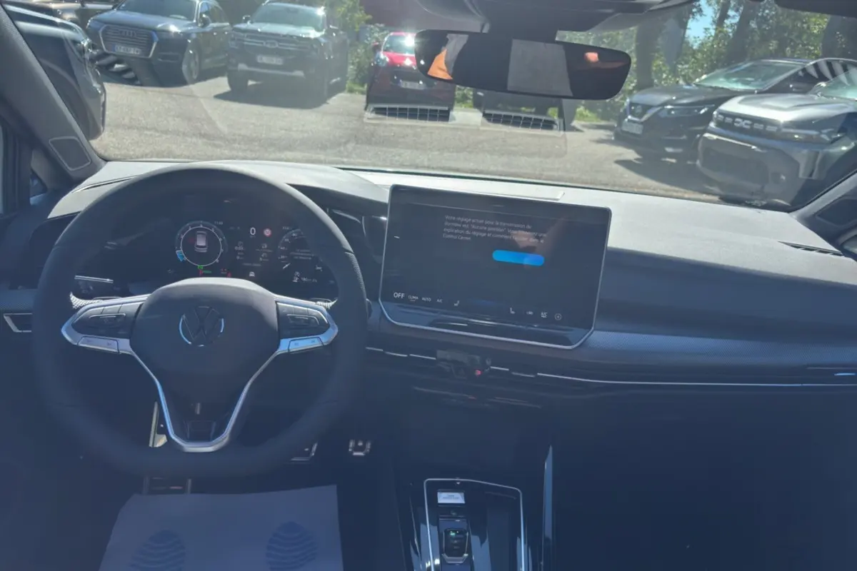 Vue intérieure centrée sur le tableau de bord et le volant multifonctions d'une Volkswagen Golf blanche oryx 2026.