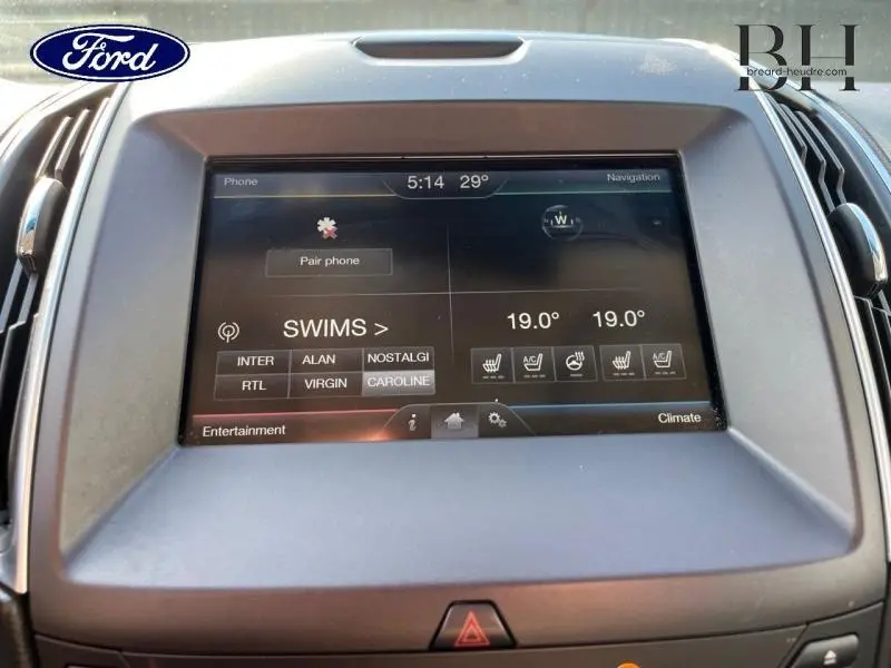 Écran tactile central du Ford Edge 2016 affichant la climatisation et les options multimédias, vue de face.