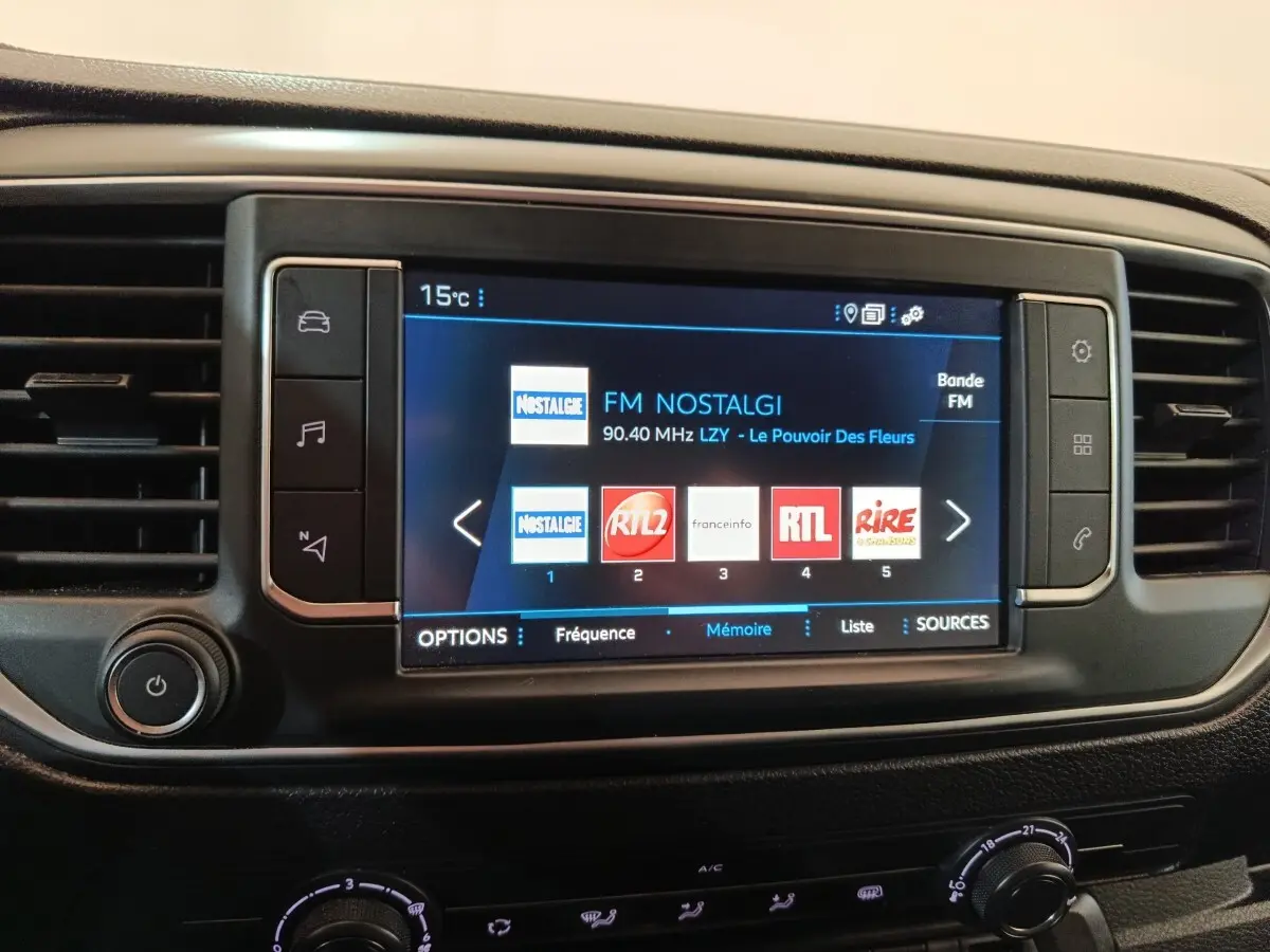 Écran tactile central du Peugeot Expert Fourgon blanc 2023 affichant les stations radio FM, entouré de commandes noires.