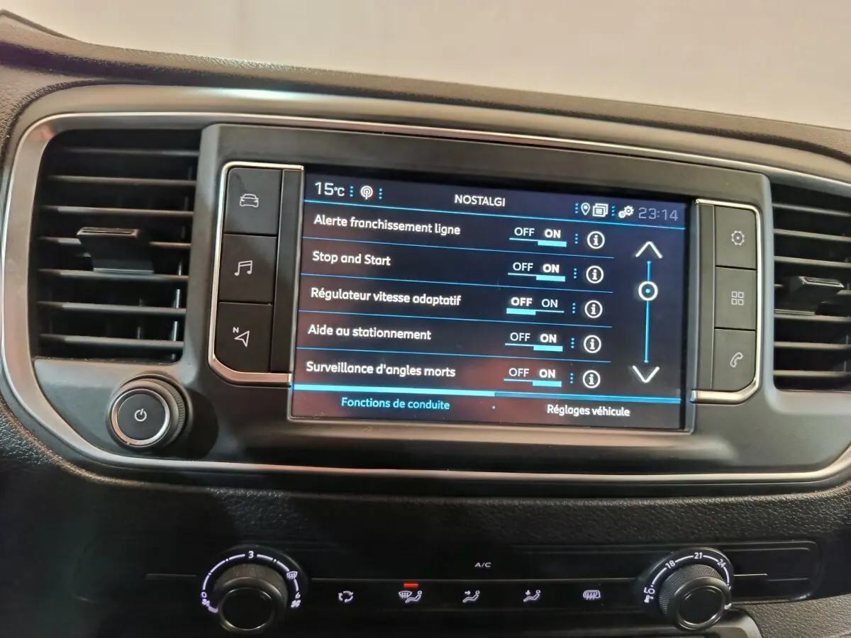 Gros plan sur l'écran tactile central du Peugeot Expert Fourgon blanc 2023 affichant les réglages d'aides à la conduite.