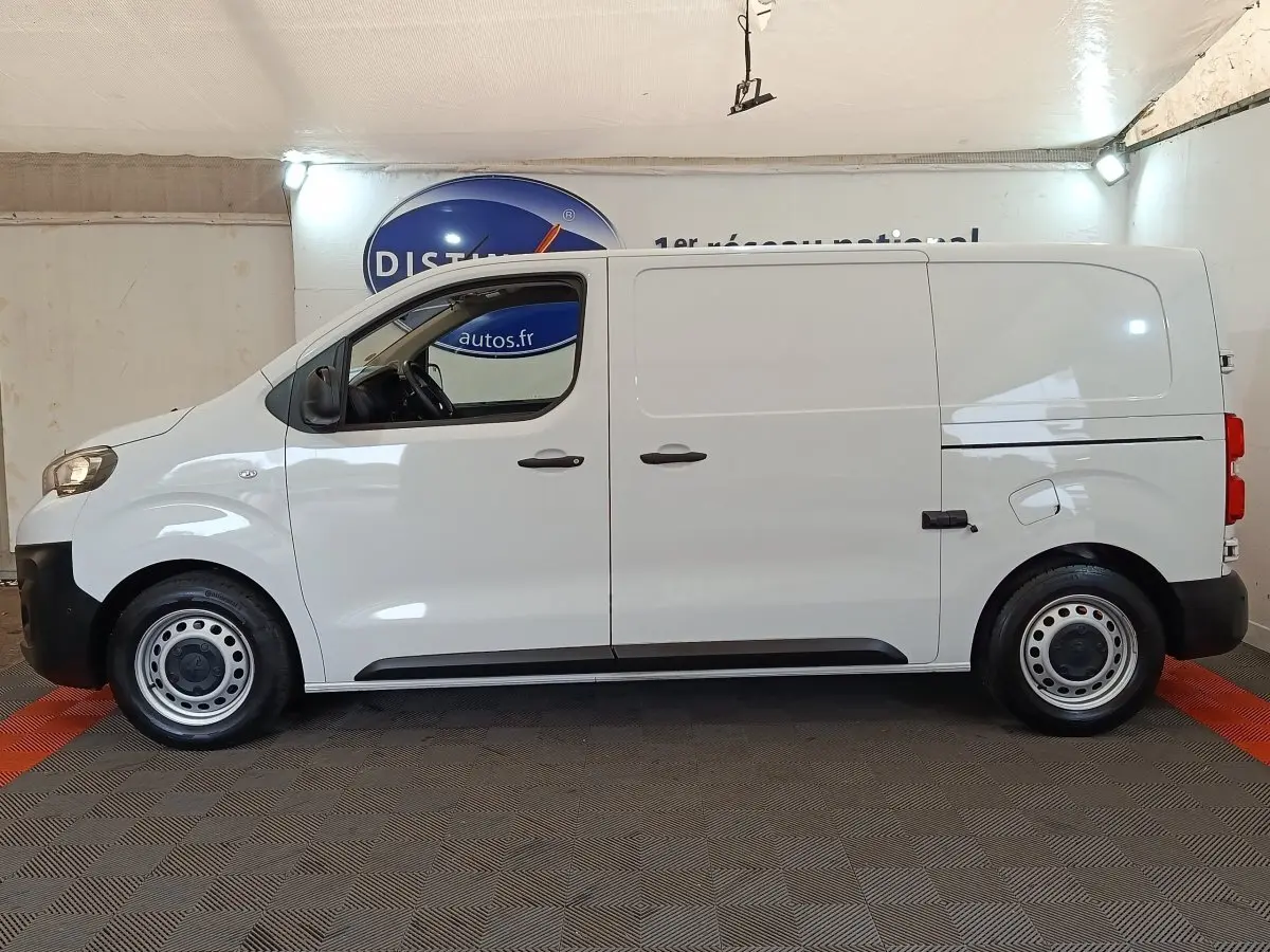Vue de profil côté gauche d’un Peugeot Expert Fourgon blanc, version Taille M, avec portes latérales pleines et jantes acier.
