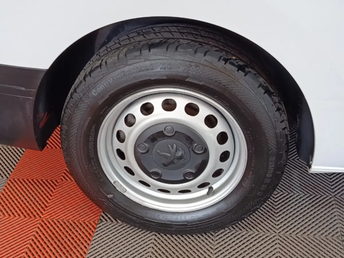 Gros plan sur la roue avant droite du Peugeot Expert Fourgon blanc, avec jante acier et logo Peugeot central.