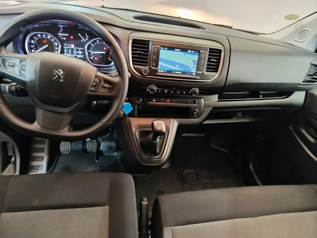 Vue intérieure avant du Peugeot Expert Fourgon 2023 avec tableau de bord noir et écran tactile central affichant la navigation.