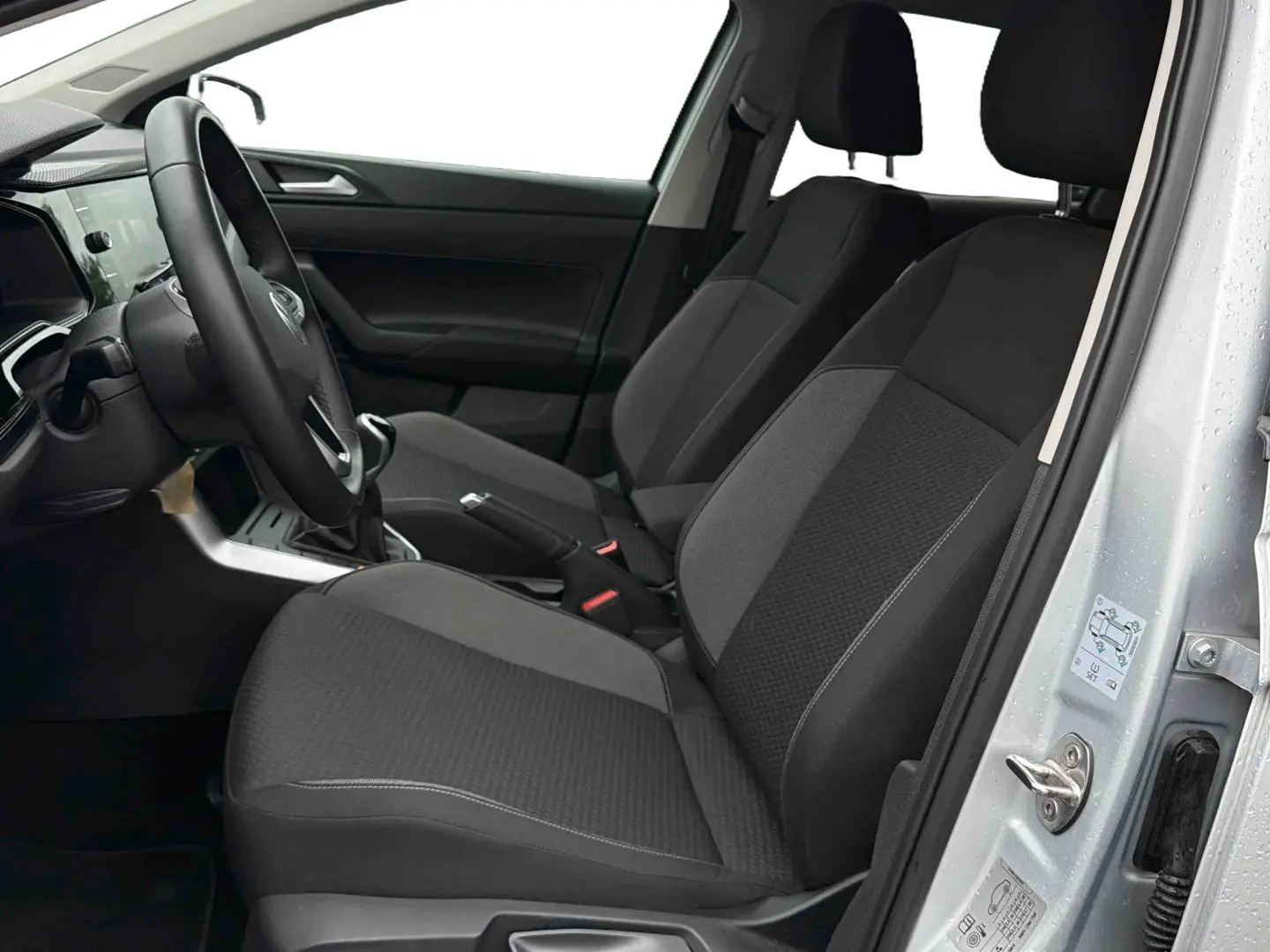 Vue intérieure côté conducteur de la Volkswagen Polo grise 2025, montrant les sièges avant et le volant multifonctions.