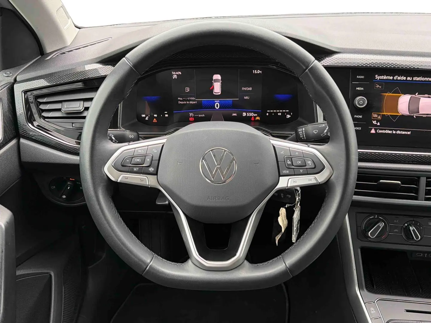 Vue intérieure centrée sur le volant multifonctions noir de la Volkswagen Polo 2025 avec tableau de bord digital et écran tactile.