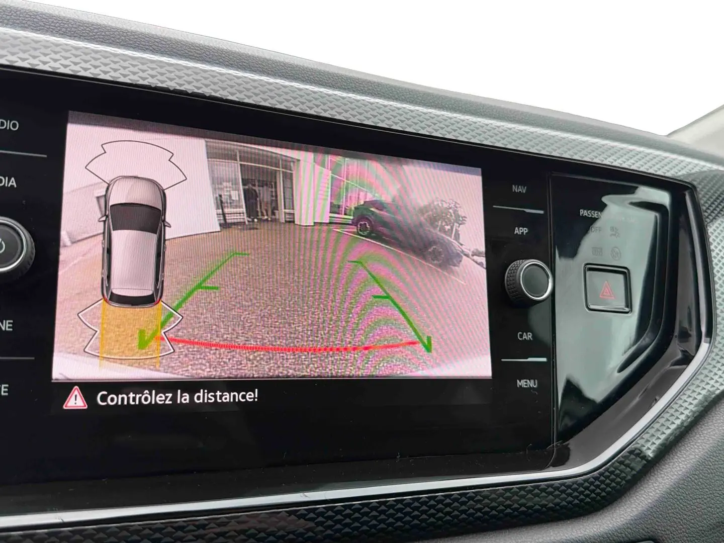 Écran tactile intérieur affichant la caméra de recul et l’aide au stationnement de la Volkswagen Polo grise.