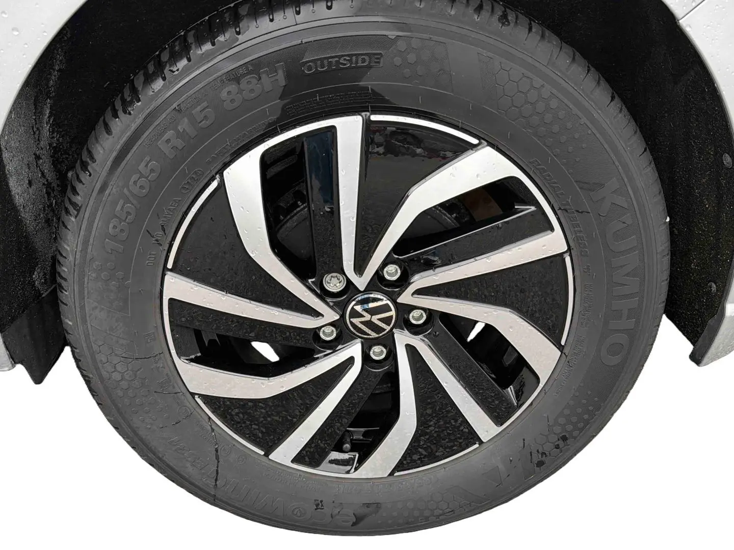 Gros plan sur la jante alliage 15 pouces bicolore noir et argent de la Volkswagen Polo grise 2025, pneu 185/65 R15 visible.