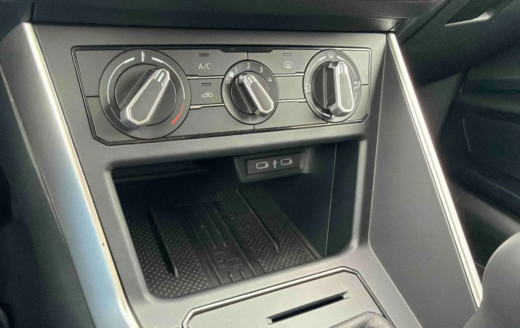 Vue rapprochée de la console centrale grise de la Volkswagen Polo 2025 avec commandes manuelles de climatisation et ports USB-C.