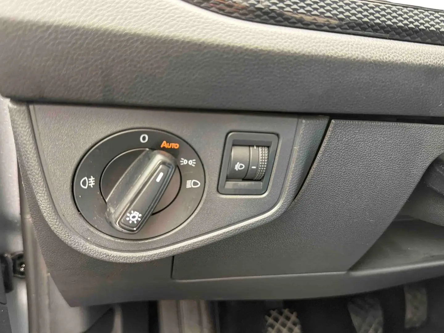 Détail du tableau de bord côté gauche avec commande d’allumage automatique des phares sur Volkswagen Polo grise 2025.