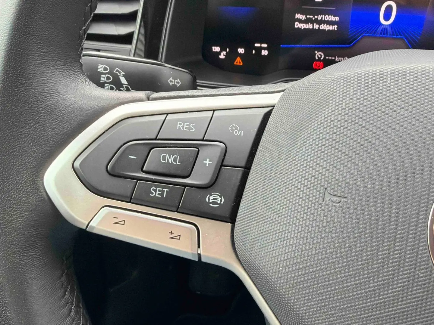 Gros plan sur les commandes au volant à gauche de la Volkswagen Polo grise 2025 avec affichage digital du tableau de bord.