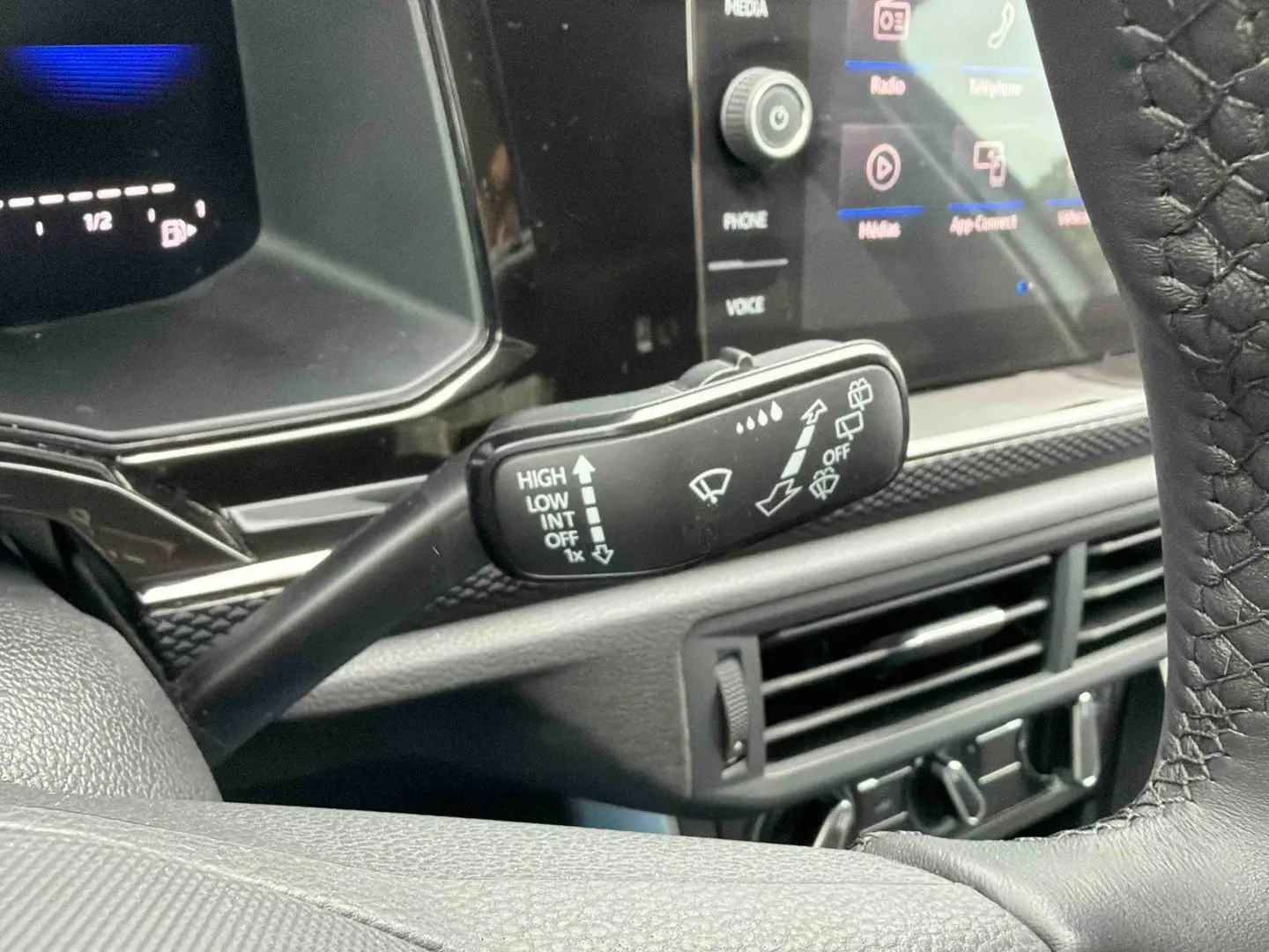 Vue rapprochée du commodo d’essuie-glace noir dans l’habitacle gris de la Volkswagen Polo 2025.