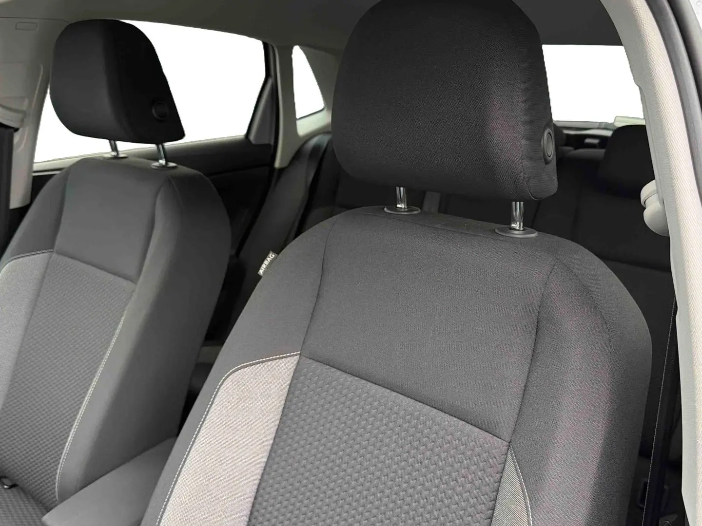 Gros plan sur les sièges avant gris foncé de la Volkswagen Polo 2025, montrant les appuie-têtes et détails de tissu.