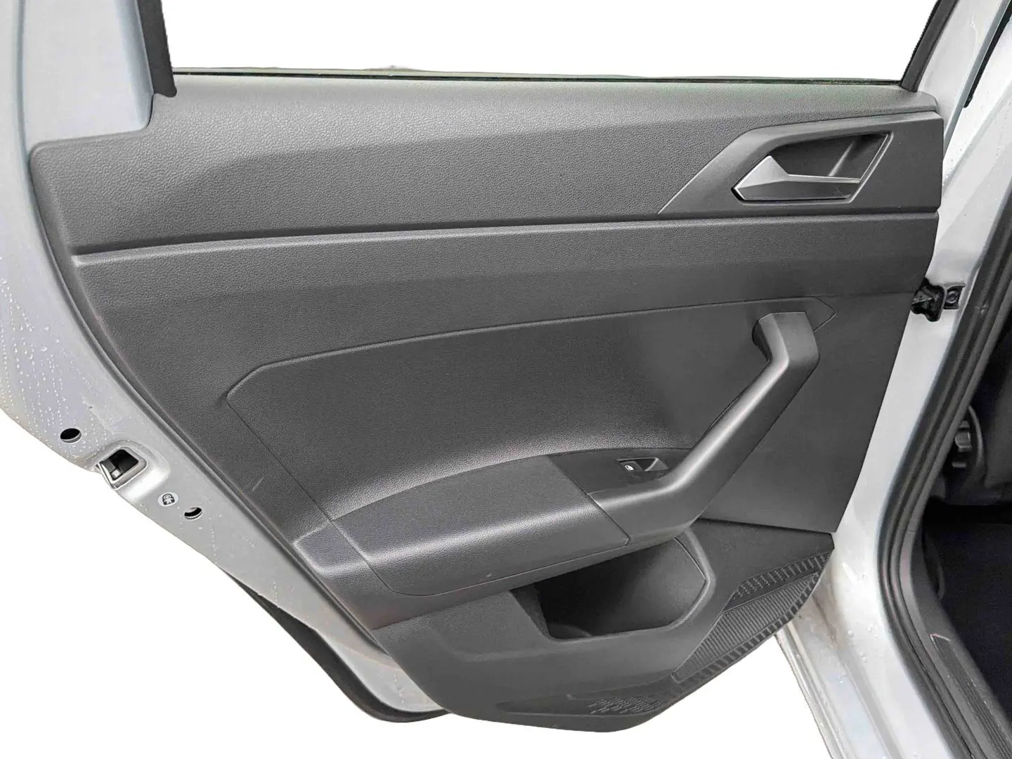 Vue rapprochée de la porte arrière gauche grise de la Volkswagen Polo 2025 avec poignée et commande de vitre noire.