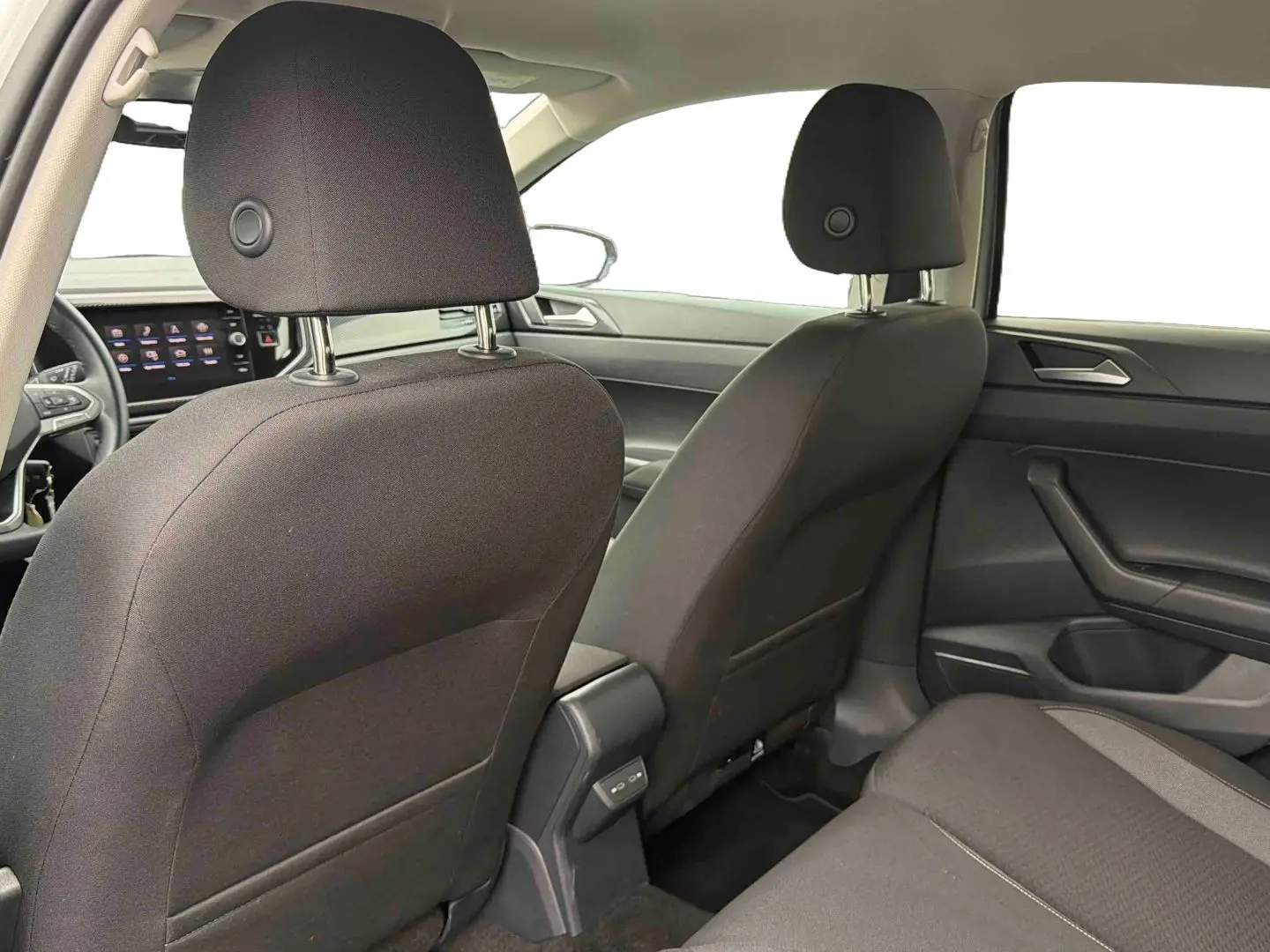 Vue intérieure arrière de la Volkswagen Polo grise 2025, montrant les sièges avant et la console centrale avec ports USB-C.