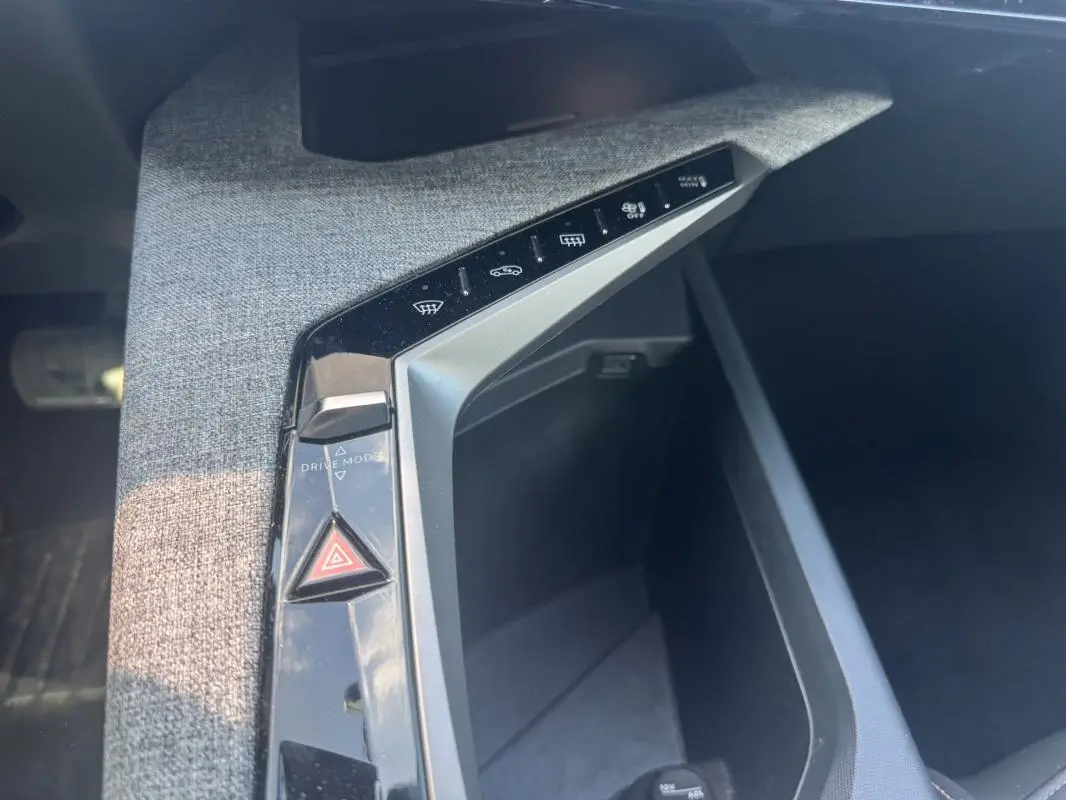 Vue rapprochée de la console centrale du Peugeot 3008 Hybrid 136 e-DCS6 Allure 2025, avec commandes tactiles et bouton triangle rouge.