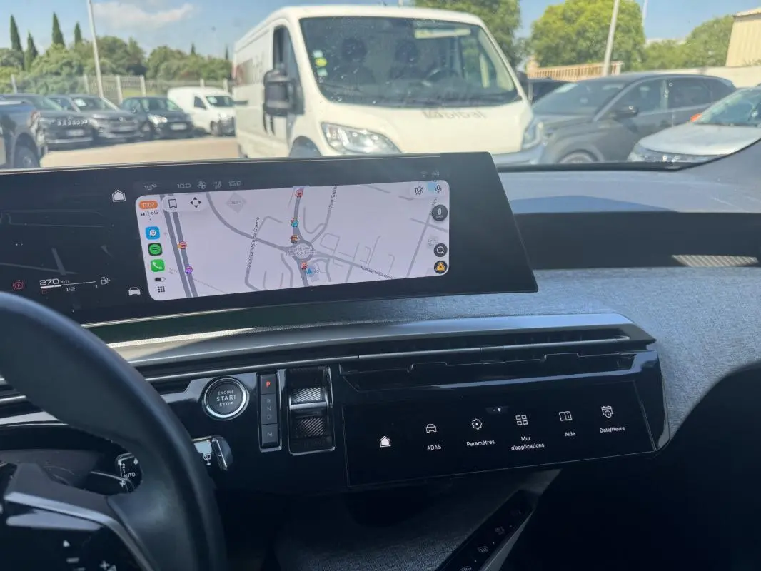 Vue intérieure du tableau de bord du Peugeot 3008 Hybrid 136 e-DCS6 Allure 2025 avec écran tactile et navigation affichée.