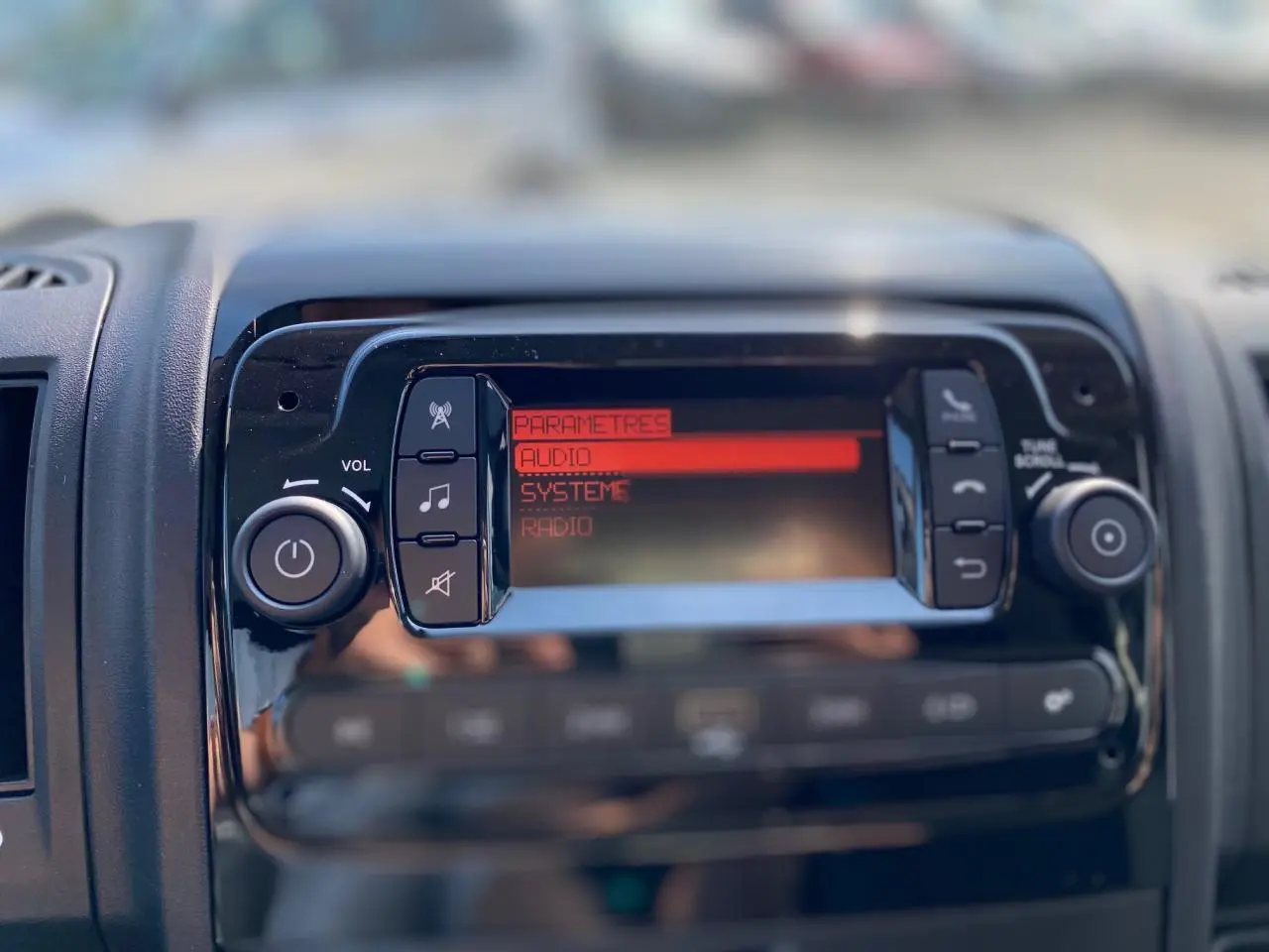 Tableau de bord du Citroën Jumper 2023 montrant l'écran audio en mode paramètres avec boutons de contrôle noirs.