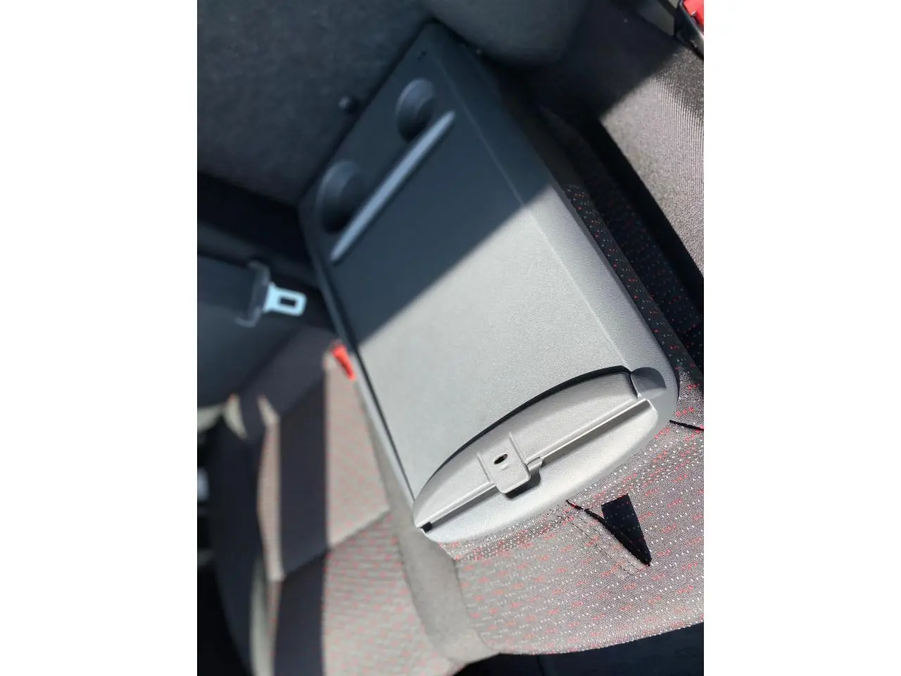 Détail de l'accoudoir central arrière avec porte-gobelets du Citroën Jumper 2023, tissu gris à motifs rouges.