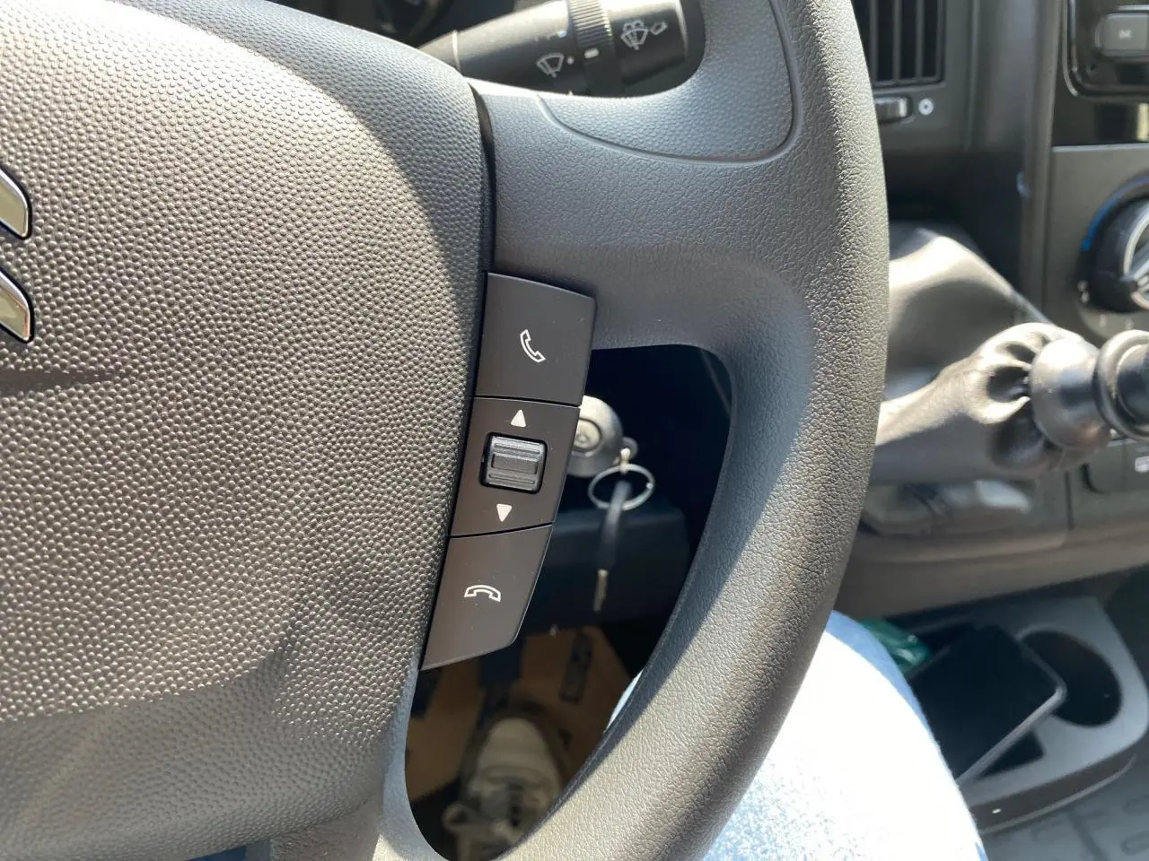 Gros plan sur le volant de la Citroën Jumper 2023 avec commandes Bluetooth et levier de vitesses manuel visible.