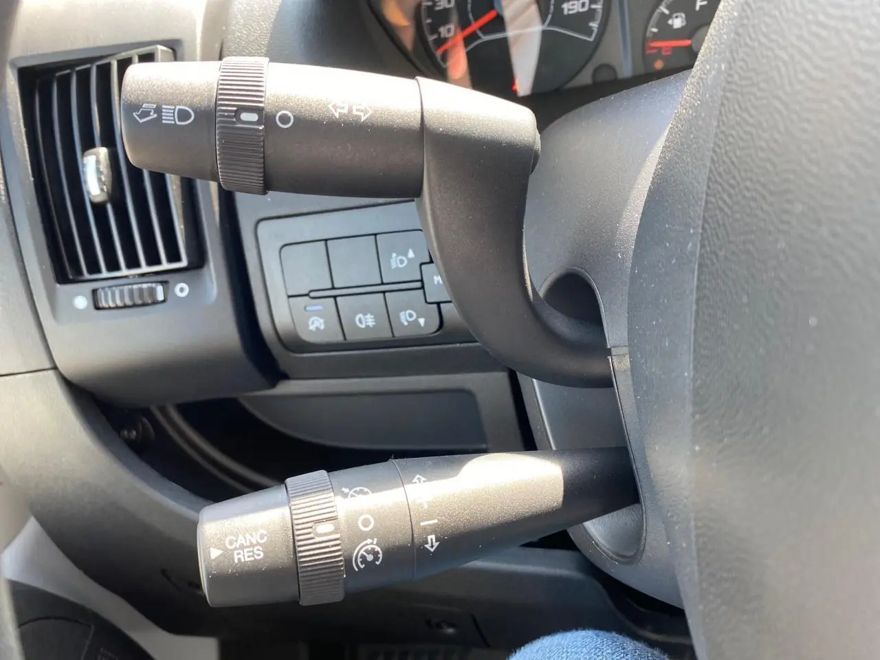 Gros plan sur les commandes de clignotants et régulateur de vitesse du tableau de bord noir du Citroën Jumper 2023.