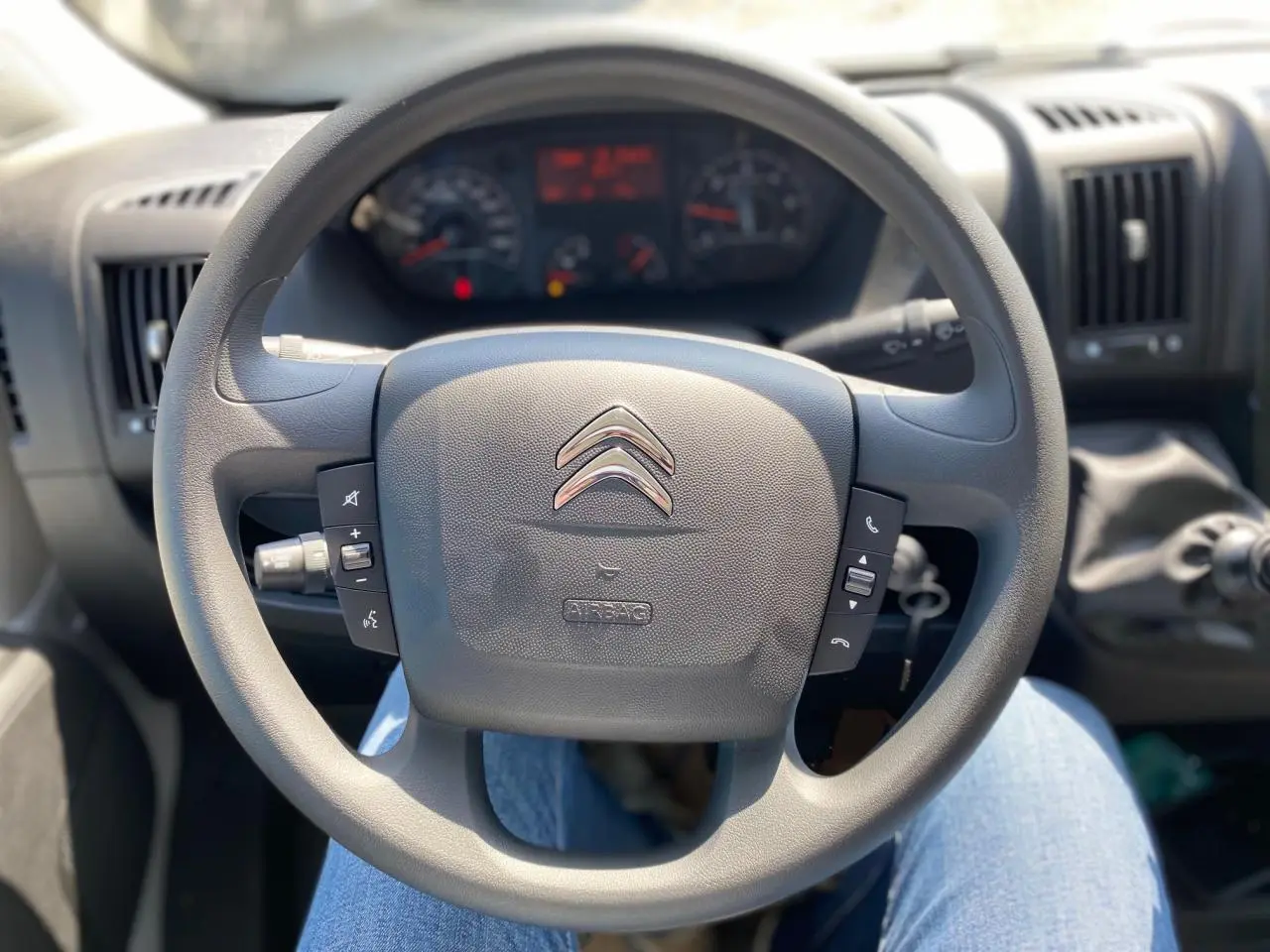 Volant Citroën Jumper 2023 vu de face avec commandes intégrées et tableau de bord en arrière-plan.