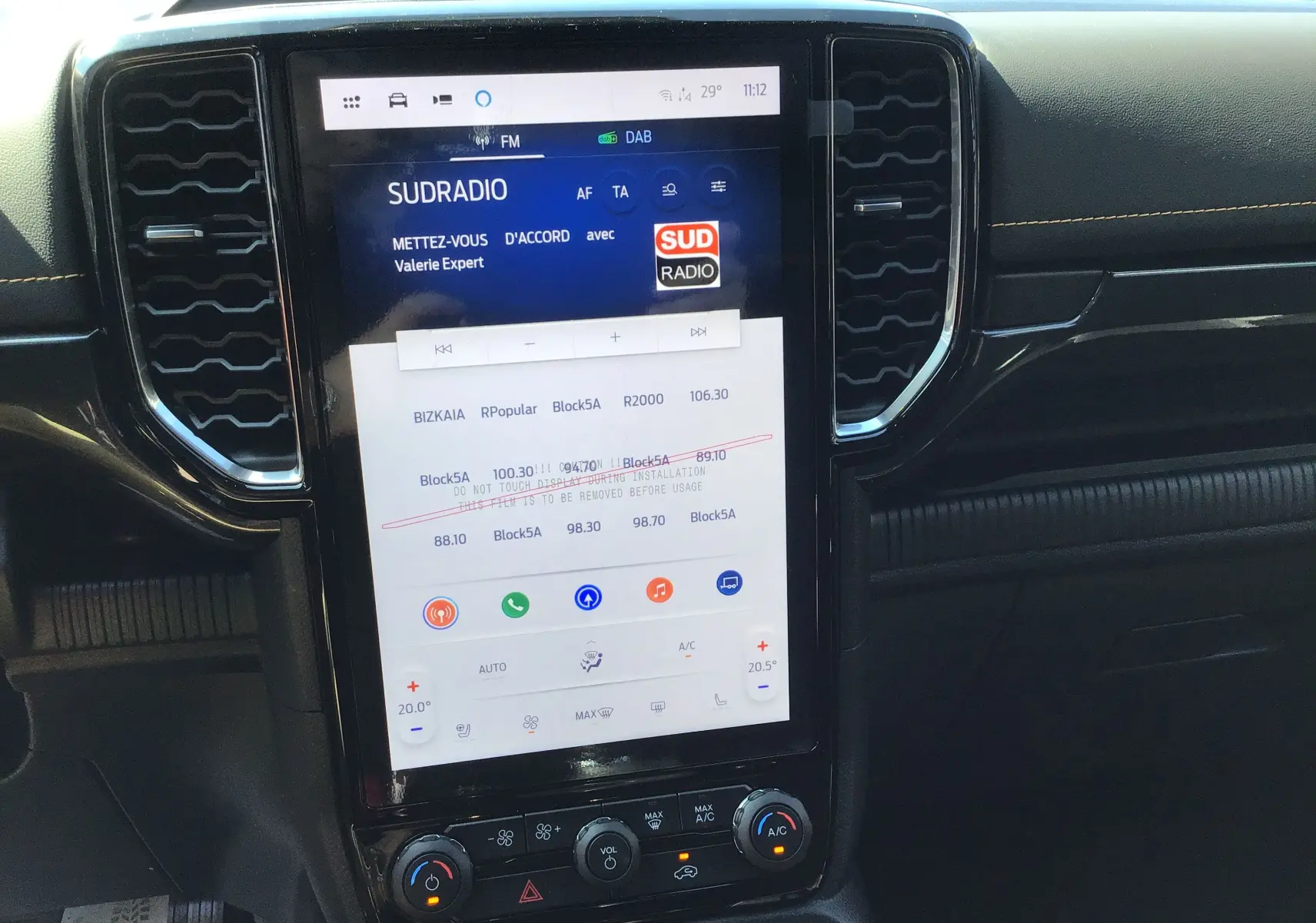 Vue rapprochée de l'écran tactile central et tableau de bord noir du Ford Ranger Wildtrak gris carbone.