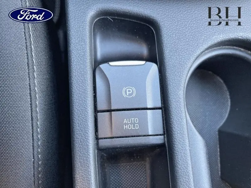 Gros plan sur la console centrale d'une Hyundai Kona 2022 Dark Knight Métal, bouton frein à main électrique et Auto Hold.