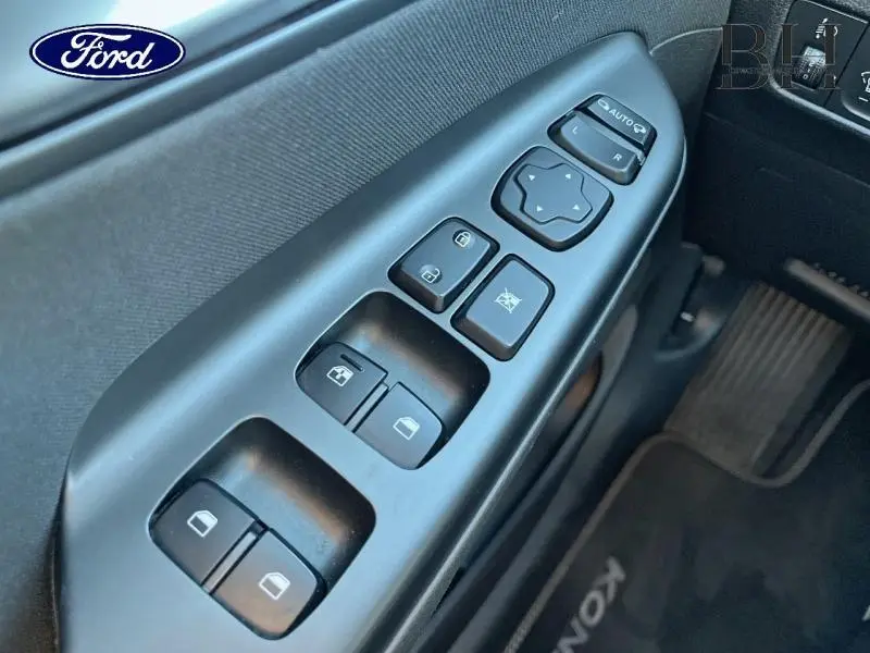 Gros plan sur les commandes de vitres et rétroviseurs côté conducteur d'une Hyundai Kona 2022 Dark Knight Métal.