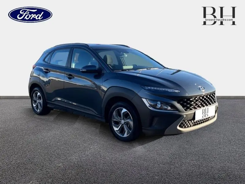 Hyundai Kona 1.6 GDi Hybrid 2022 en Dark Knight Métal, vue 3/4 avant droit avec calandre distinctive et jantes alu.
