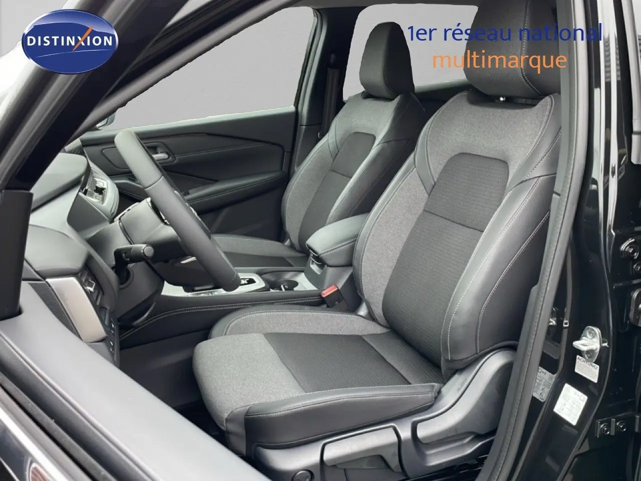 Vue intérieure côté conducteur du Nissan Qashqai 2025 noir perle métal, mettant en valeur les sièges tissu et cuir bicolores.