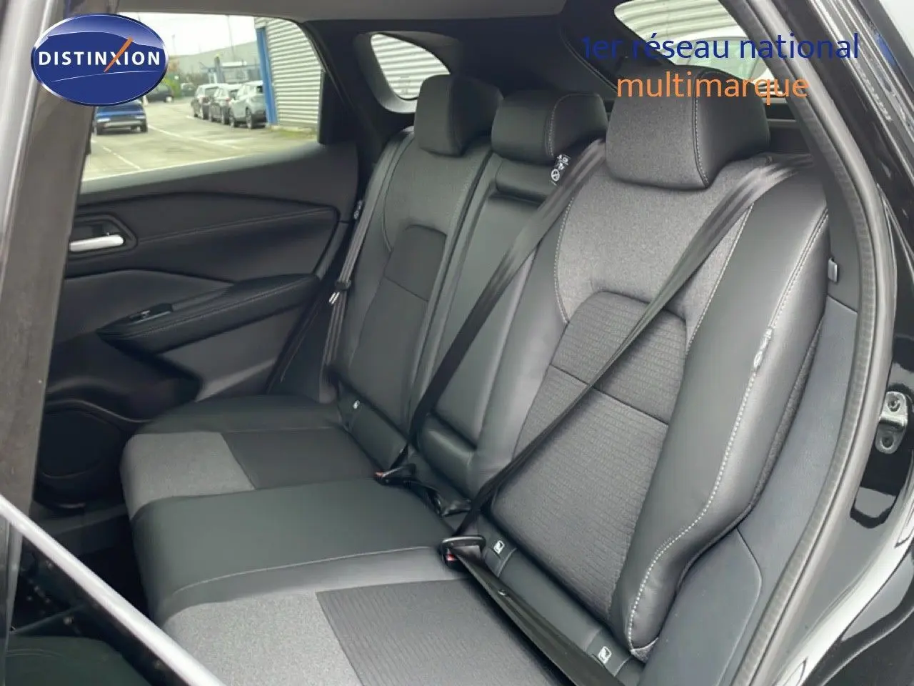 Vue intérieure arrière du Nissan Qashqai 2025 noir perle métal, sièges mixtes cuir et tissu avec ceintures attachées.