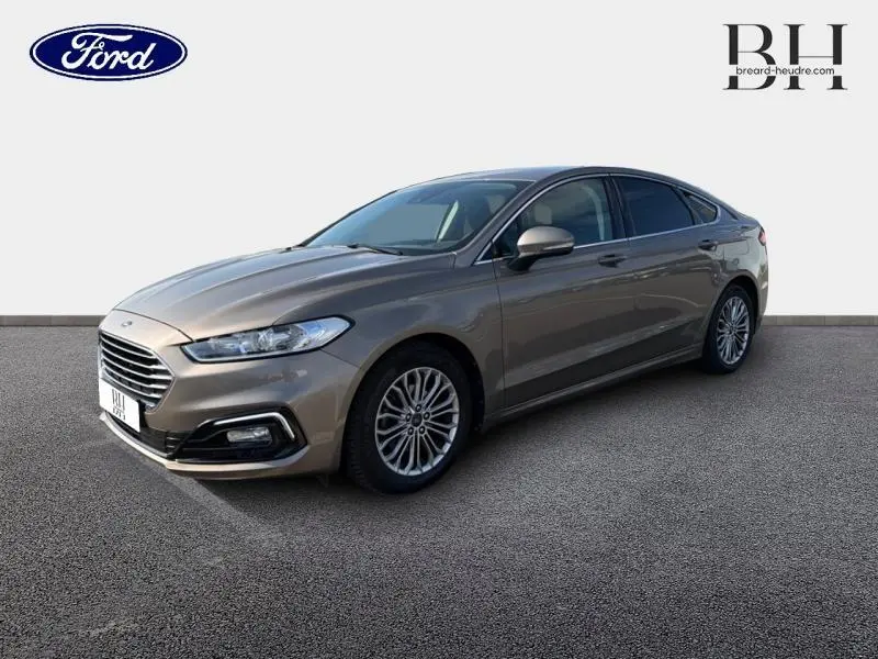 Ford Mondeo 2.0 EcoBlue gris Millenium vue 3/4 avant droit, avec calandre chromée et jantes alliage multi-branches.