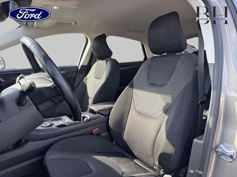 Vue intérieure côté conducteur de la Ford Mondeo 2.0 EcoBlue 2021 avec sièges sport noirs et volant cuir multifonction.