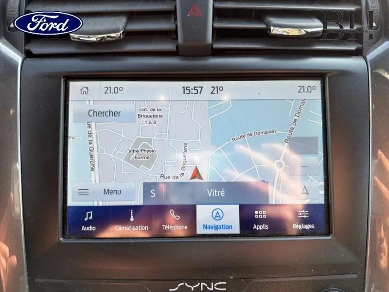 Vue rapprochée de l'écran tactile de navigation du Ford Mondeo gris, affichant une carte et les commandes multimédia.