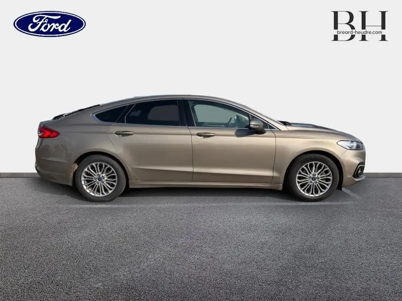 Vue de profil côté droit d'une Ford Mondeo 2021 gris Premium Millenium avec jantes alliage et vitres teintées.