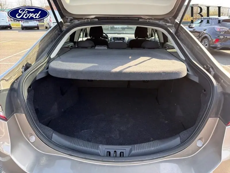 Vue arrière du coffre ouvert d'une Ford Mondeo 2.0 EcoBlue gris Premium Millenium, avec cache-bagages en place.