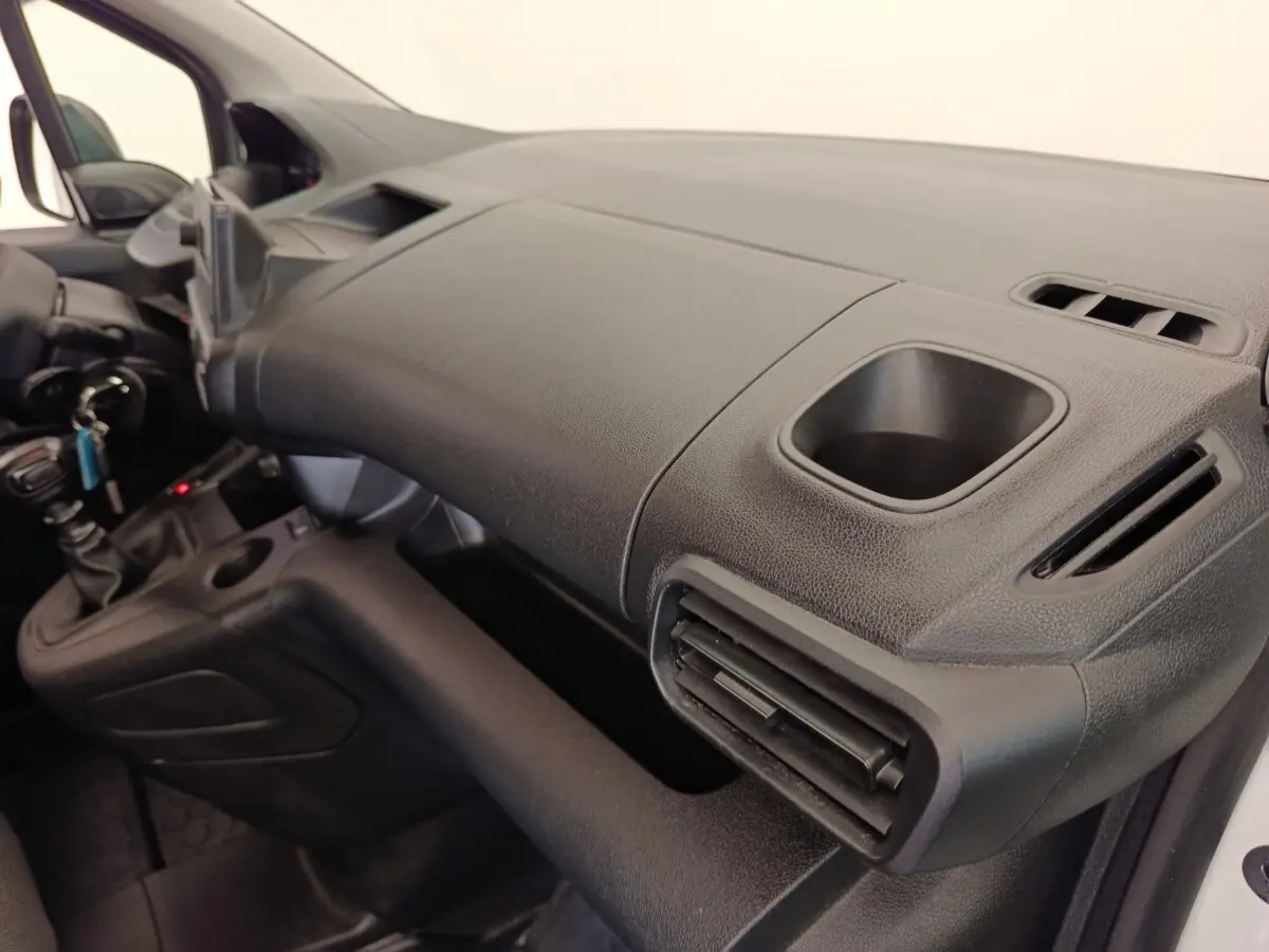 Vue intérieure côté passager du tableau de bord noir du Peugeot Partner 2022 avec porte-gobelet intégré.