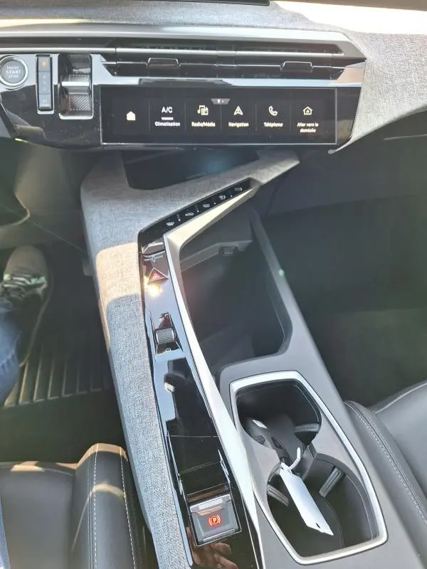 Vue intérieure du Peugeot 3008 Hybrid 136 e-DCS6 Allure 2025, console centrale avec écran tactile et finition tissu gris.