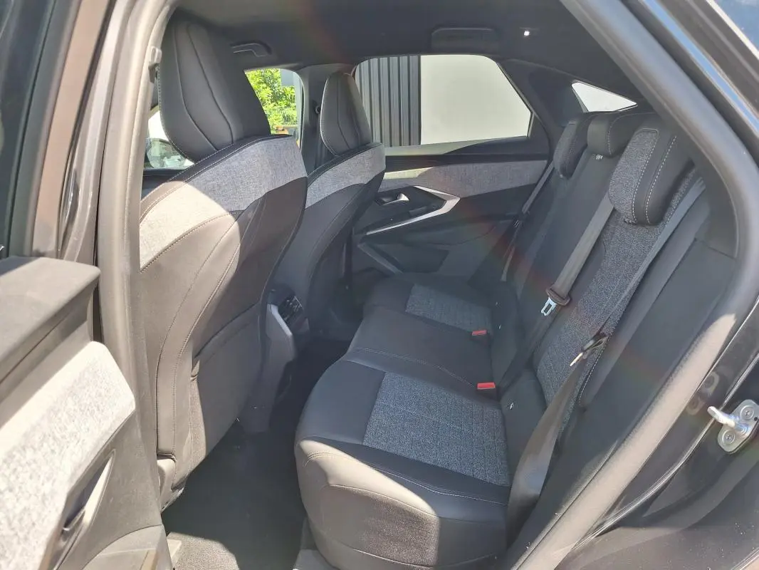 Vue intérieure côté droit des sièges arrière du Peugeot 3008 Hybrid gris foncé, avec sellerie tissu et cuir bicolore.