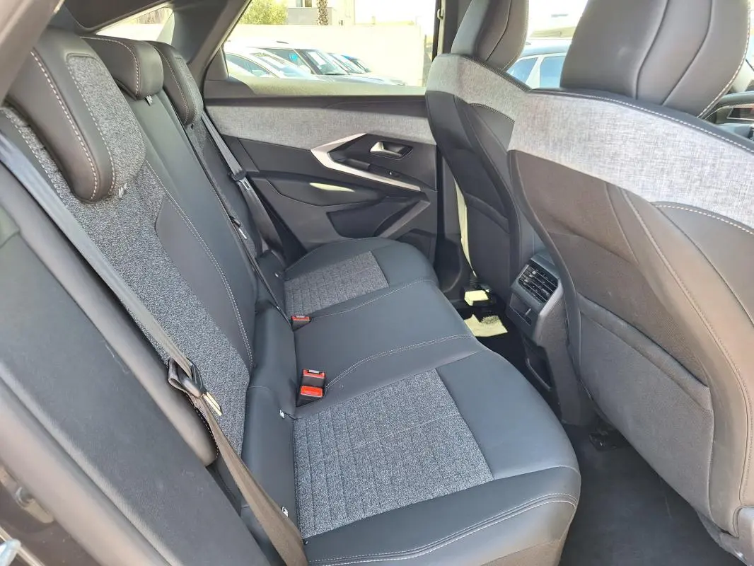 Vue intérieure arrière côté droit du Peugeot 3008 Hybrid 136 Allure 2025, sièges bicolores gris et noir avec surpiqûres.