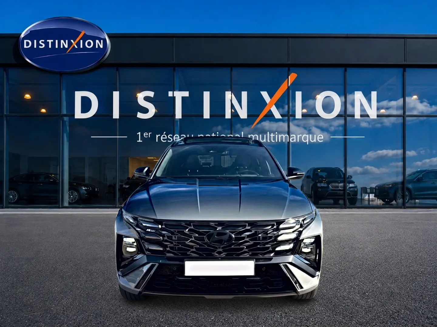 Vue frontale du Hyundai Tucson 2026 gris shadow avec calandre noire et signature lumineuse LED distinctive.