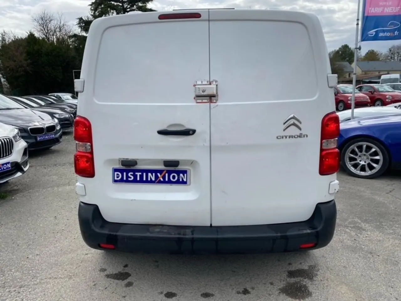 Vue arrière d'un utilitaire blanc Citroën Jumpy 2019 avec portes battantes et logo visible sur parking.