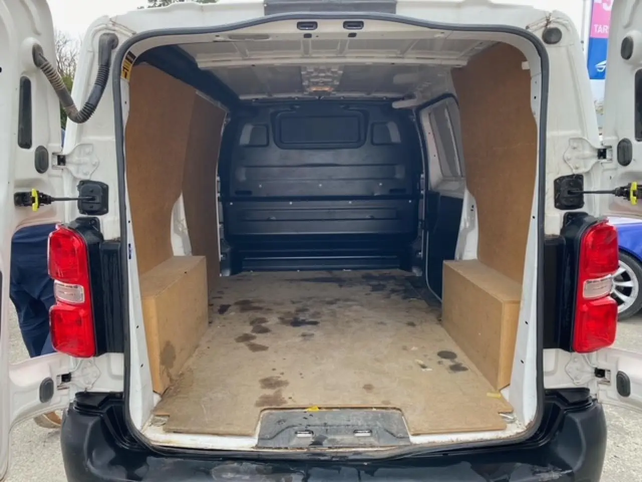 Vue arrière ouverte du Citroën Jumpy blanc 2019 avec plancher et habillage bois dans l'espace de chargement.