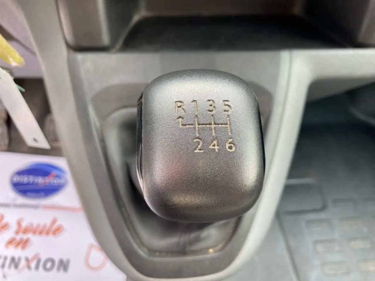 Gros plan sur le levier de vitesses manuel noir du Citroën Jumpy blanc, montrant les six rapports et la marche arrière.