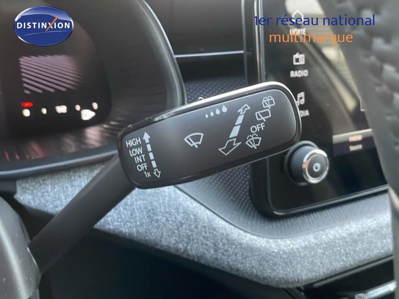 Gros plan sur la manette d’essuie-glace du Skoda Kamiq 2025, intérieur gris argent métallisé avec tableau de bord numérique.