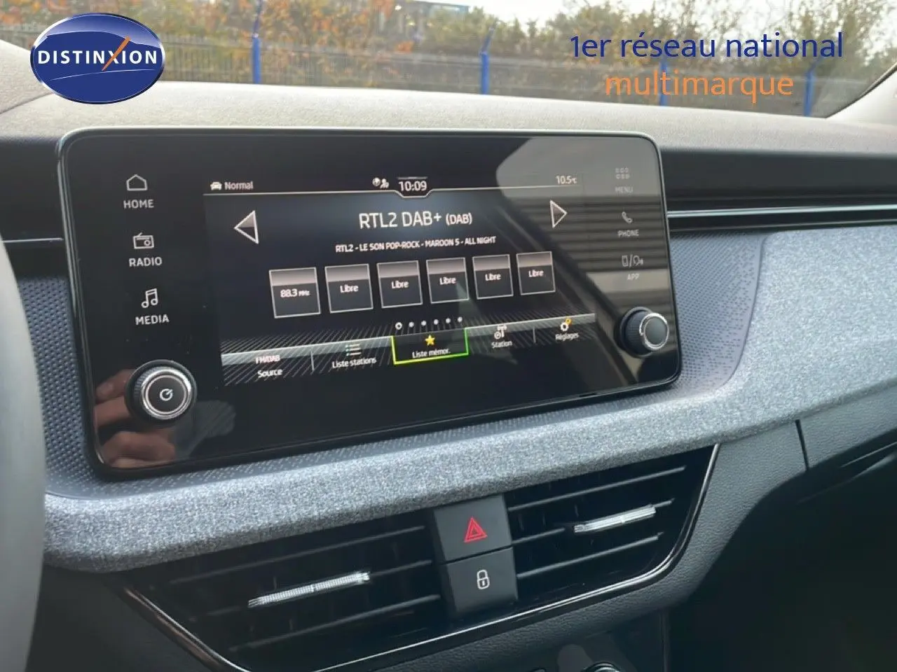 Écran tactile central du tableau de bord gris argent d'une Skoda Kamiq 2025, avec interface radio numérique visible.