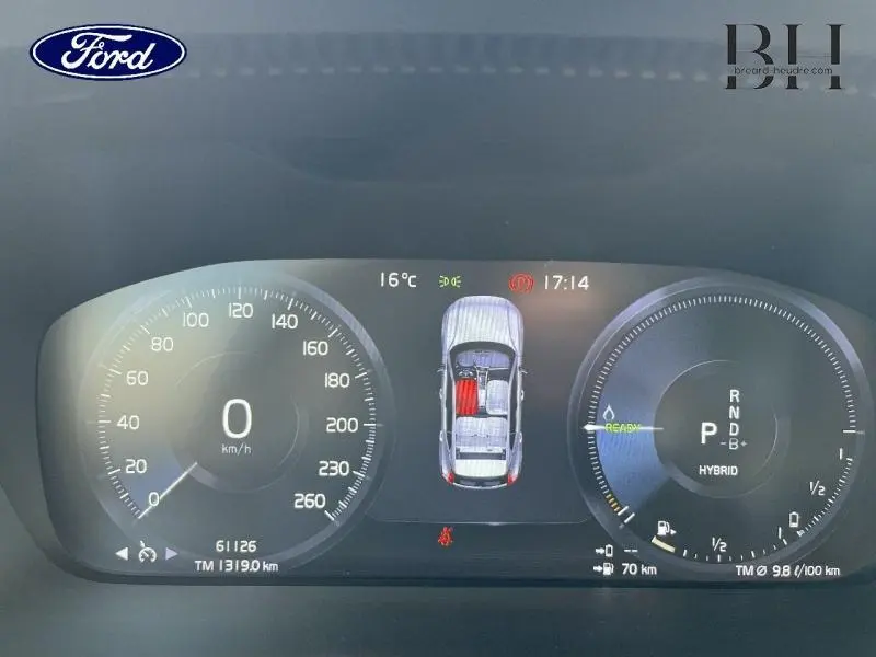 Tableau de bord numérique du Volvo XC40 T5 Recharge gris glacier, affichant vitesse, mode hybride et état des portes.