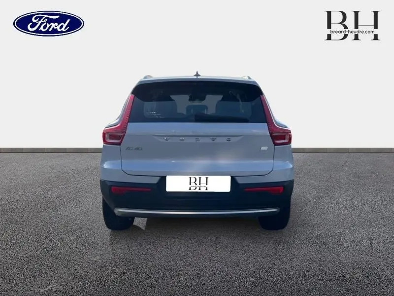 Vue arrière d'un Volvo XC40 T5 Recharge gris glacier, mettant en valeur ses feux arrière en forme de L et son pare-chocs noir.