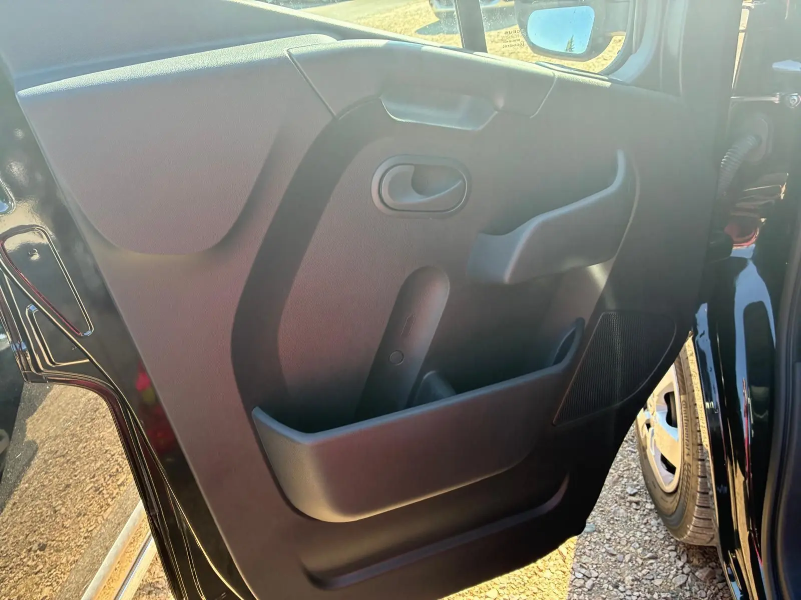 Vue rapprochée de la porte intérieure côté gauche du Renault Master gris 2023, montrant la poignée et les rangements.