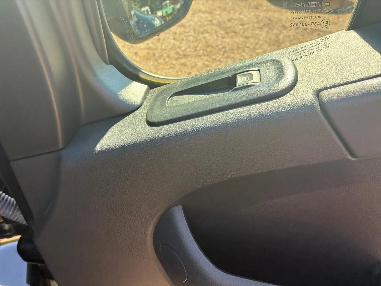 Détail de la commande de lève-vitre côté gauche dans l’habitacle du Renault Master gris 2023.